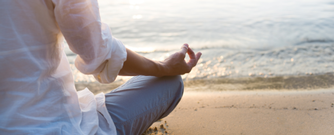 person meditating at the beach