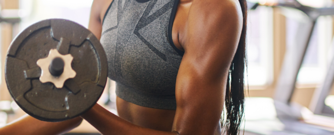 woman in gym curling dumbells