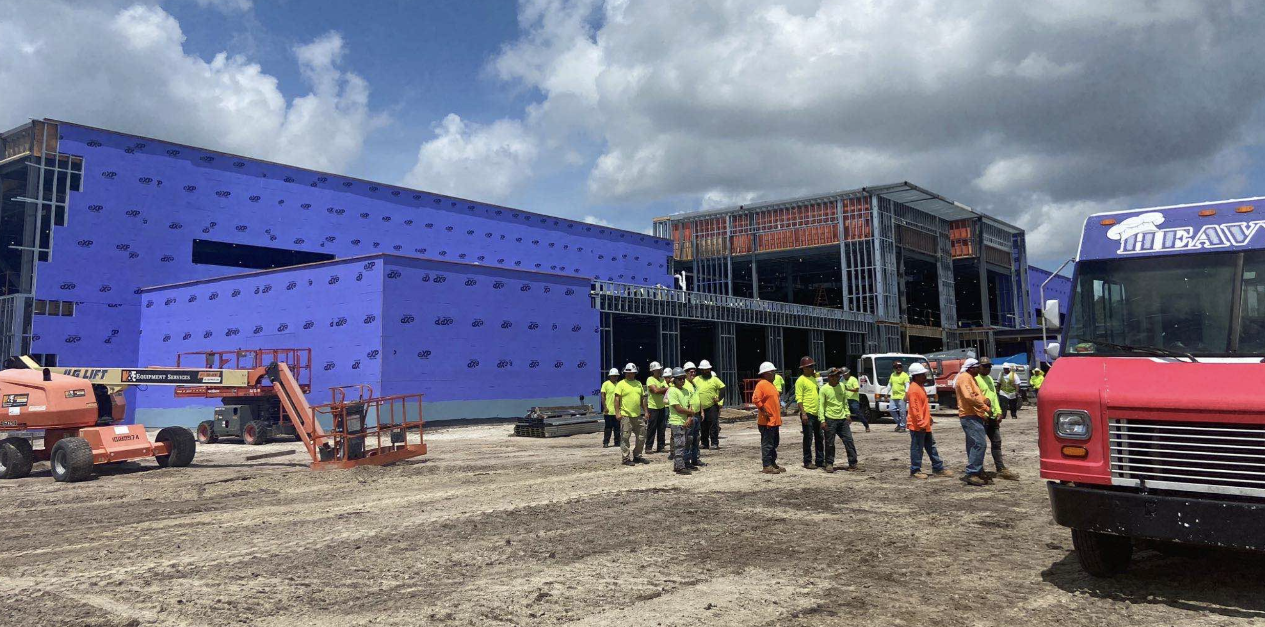 constructiion workers lining up for food truck at construction site at coastal orthopedics