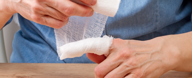 Person wrapping index finger in bandages