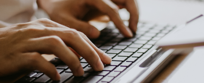 pair of hands typing on keyboard