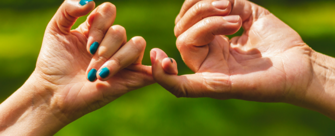 couple holding hands via pinky finger