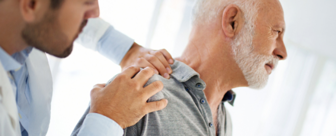 man with disocated sholder being examined by doctor