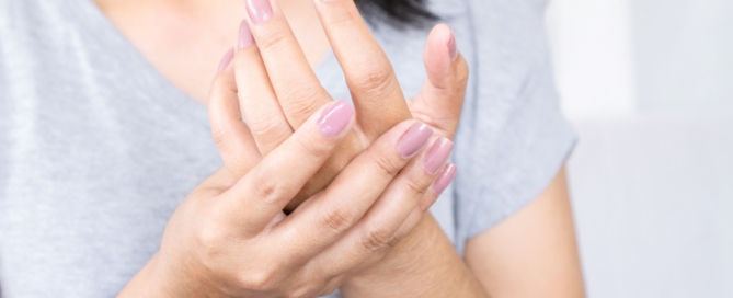 woman holding her examining her hand