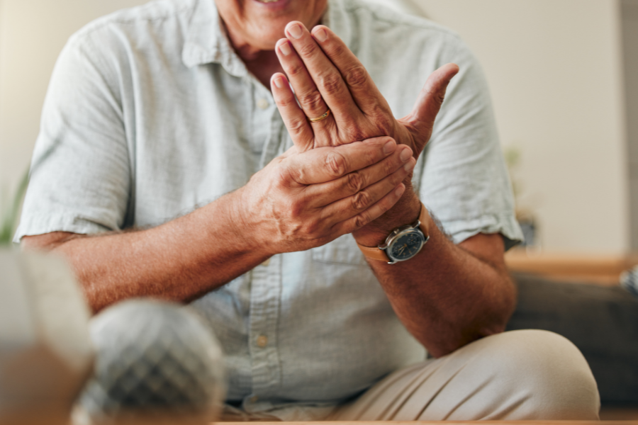 senior citizen holdigng wrist in pain