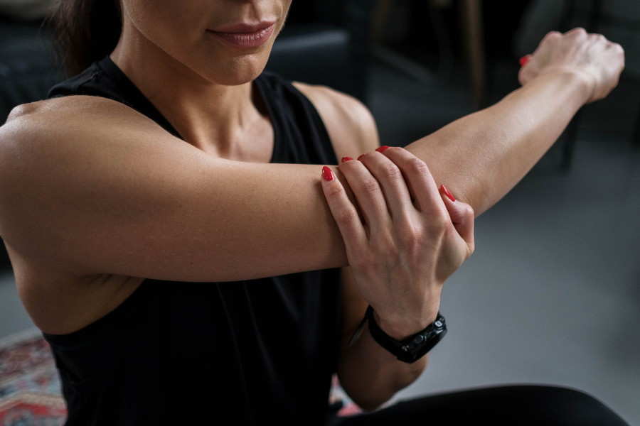 woman stretching harm with hand on elbow