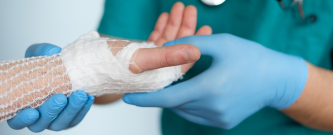 medical professional examining bandaged hand