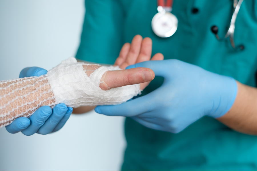 medical professional examining bandaged hand