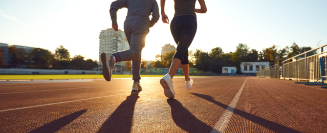 two adults jogging on a track