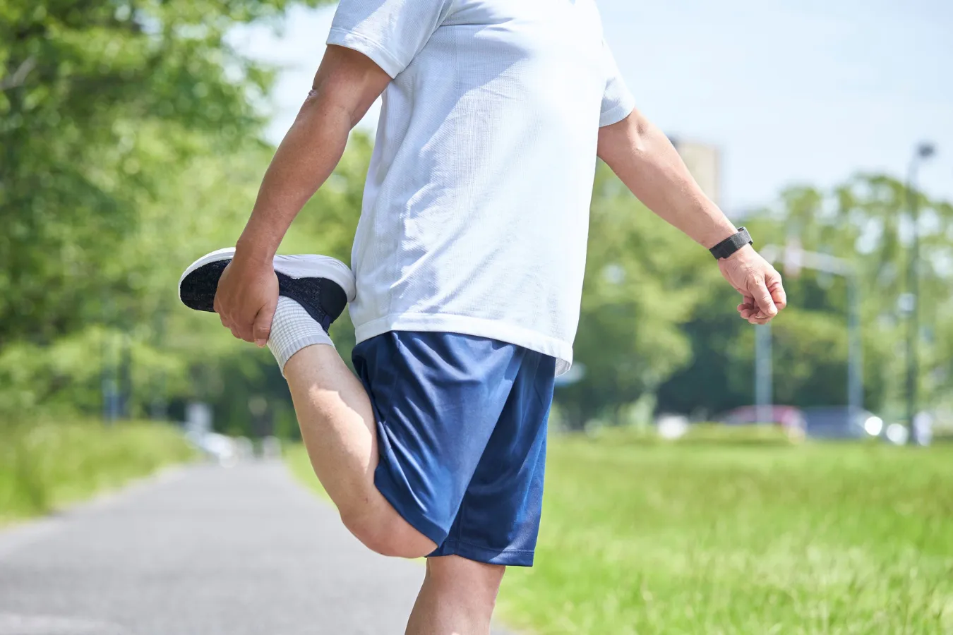 Person performing a standing leg stretch to help relieve sciatica symptoms and lower back pain.